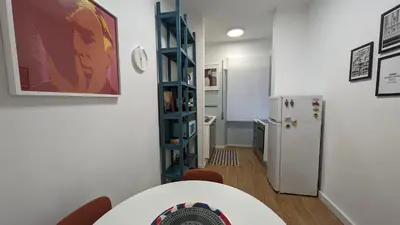 a kitchen with a refrigerator and a table and a room at Euforia House in Rome