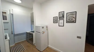 a kitchen with a refrigerator and pictures on the wall at Euforia House in Rome