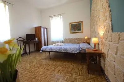 a bedroom with a bed in a room with a stone wall at Sara Holiday House in Rome
