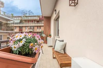 a balcony with a bench and flowers on a building at Cornelia Elegance House in Rome