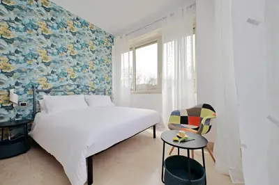 a bedroom with a bed and a window and a chair at Homely Flat Porta Maggiore in Rome