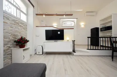 a living room with a flat screen tv on the wall at Domus Monamì Apartment in Rome