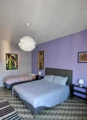 a bedroom with two beds and a purple wall at CASA UMBERTO in Rome