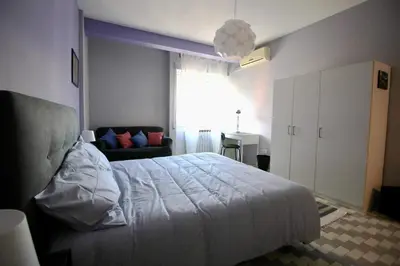 a bedroom with a white bed and a couch at CASA UMBERTO in Rome
