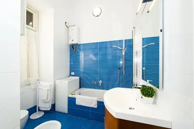 a blue and white bathroom with a toilet and a sink at Home Candia in Rome
