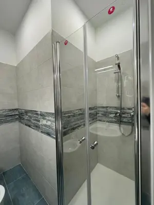 a shower with a glass door in a bathroom at Costantino Rooms in Rome