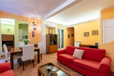 a living room with a red couch and a dining room at Casa Rio by Hili in Rome