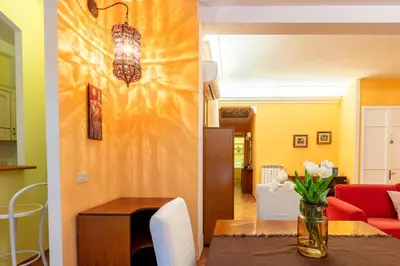 a living room and dining room with a vase of flowers on a table at Casa Rio by Hili in Rome