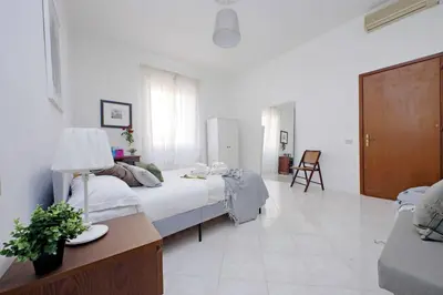 a bedroom with two beds and a table and a chair at Giant Cola di Rienzo Apartment in Rome