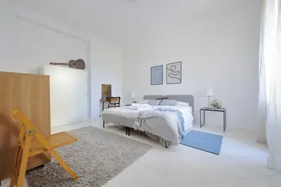a white bedroom with a bed and a table at Giant Cola di Rienzo Apartment in Rome