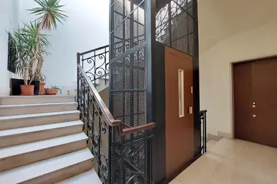 a staircase with a wrought iron railing and a door at Giant Cola di Rienzo Apartment in Rome