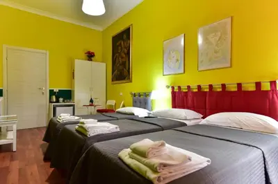 two beds in a room with yellow walls at Best Rooms Termini in Rome