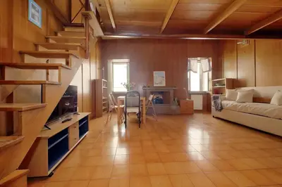 a living room with a staircase and a room with a couch at Appartamento 