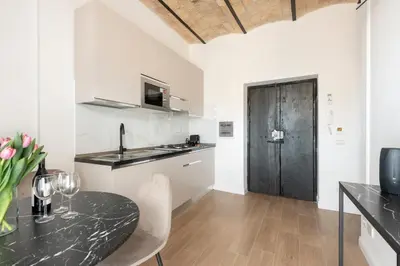 a kitchen with a table and a black counter top at W STUDIO TERMINI in Rome