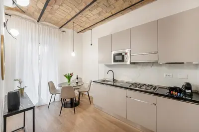 a kitchen with white cabinets and a table with chairs at W STUDIO TERMINI in Rome