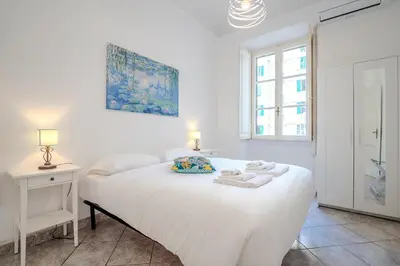 a white bedroom with a white bed and a window at Tomo Apartment St. Peter's in Rome