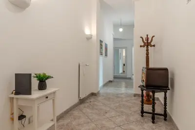 a hallway with a room with a tv and a chair at Tomo Apartment St. Peter's in Rome