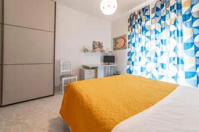 a bedroom with a bed with a yellow bedspread at Luisa Flat - Metro Basilica San Paolo - Wi-Fi in Rome