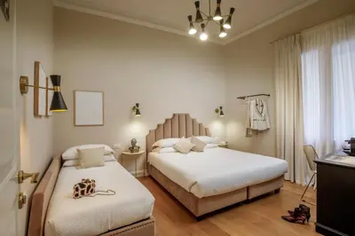 a bedroom with two beds and a chandelier at Daplace - Santa Susanna Suites in Rome