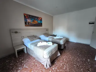 a room with two beds and a painting on the wall at Appartamento Hector in Rome