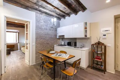 a kitchen with a table and chairs in a room at Luxury Fori Imperiali Apartment in Rome
