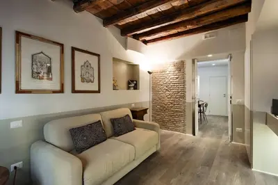 a living room with a couch and a brick wall at Luxury Fori Imperiali Apartment in Rome