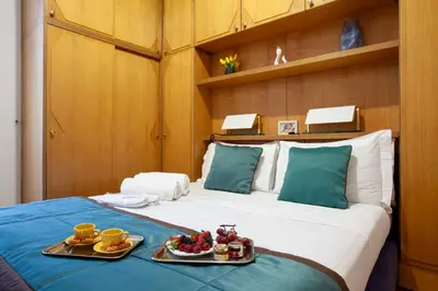 a hotel room with a bed with two plates of food on it at Harry's Bar Trevi Luxury Apartments - Sardegna in Rome