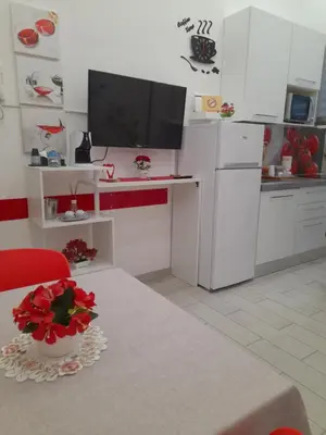 a white kitchen with a table and a tv at Apartment Nido di Roma Suite, Jacuzzi King Size, Metro C in Rome