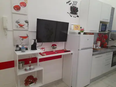 a white kitchen with a tv on a counter at Apartment Nido di Roma Suite, Jacuzzi King Size, Metro C in Rome