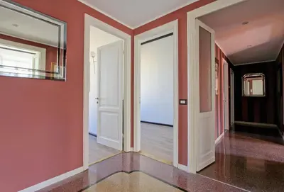 an empty hallway with red walls and white doors at Tibullo ,Classico ed Elegante Appartamento in Rome
