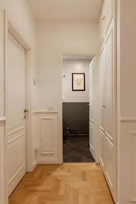 an empty hallway with white walls and wooden floors at Toscana 6 - FromhometoRome in Rome