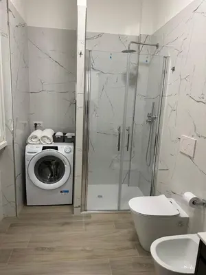 a bathroom with a shower and a washing machine at Casa Giorgia a 4 fermate metro dal Vaticano in Rome