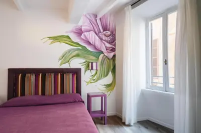 a bedroom with a flower mural on the wall at Famo Pace apartments in Rome