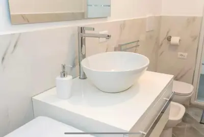 a bathroom with a white bowl sink on a counter at Apartment Colli [3m metro] in Rome