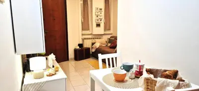 a living room with a table and a room with a couch at A casa di chi, Family, Near Metro in Rome