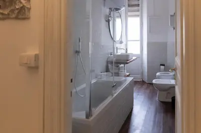 a white bathroom with a tub and a toilet at Giuliana Apartment Vatican in Rome