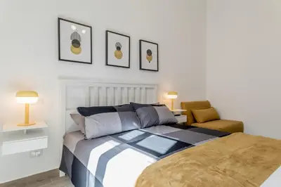 a bedroom with a bed and a chair at Elena's house in Rome