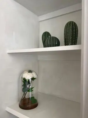 a shelf with a vase of flowers and cacti at Penthouse 23 - Vatican Charming Apartment in Rome