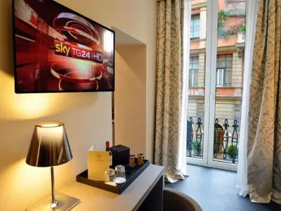 a living room with a tv and a window at Trevi Palace Hotel in Rome