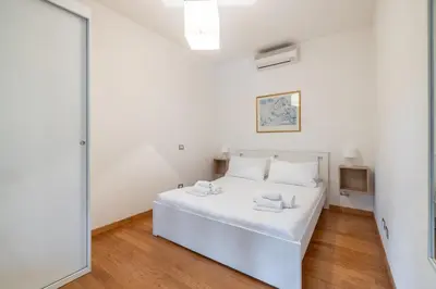 a white bedroom with a white bed and a mirror at Vatican home garden by Varental in Rome