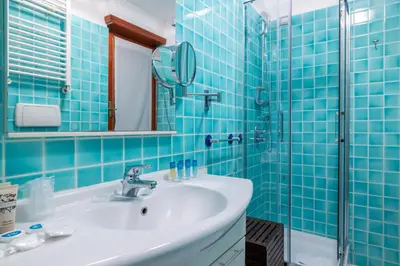 a blue tiled bathroom with a sink and a shower at Vatican home garden by Varental in Rome
