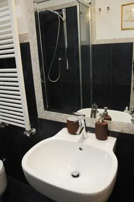 a bathroom with a white sink and a shower at A Casa di Lu, al Colosseo - Guest House in Rome