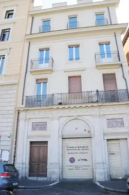 a large white building with two garage doors at A Casa di Lu, al Colosseo - Guest House in Rome