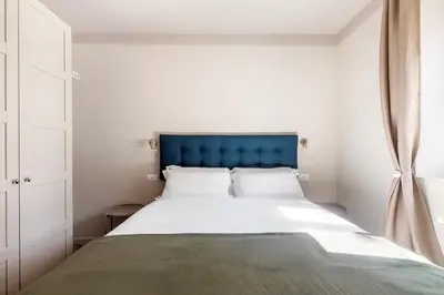a bedroom with a large bed with a blue headboard at Vatican Stunning 2 BR Apartment in Rome