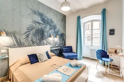 a bedroom with a bed and a blue chair at NALA & KIRA - Two big apartments for groups in the center of Rome in Rome