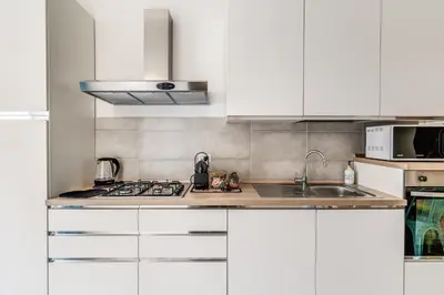 a white kitchen with white cabinets and a sink at NALA & KIRA - Two big apartments for groups in the center of Rome in Rome