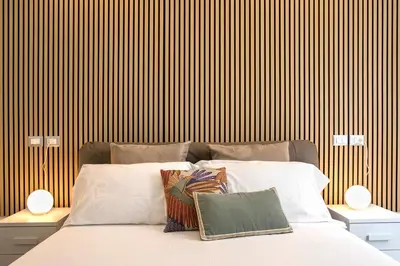 a bedroom with a bed with white pillows and a wooden wall at Domus White in Rome