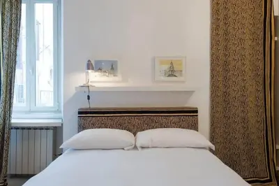 a bedroom with a white bed with two pillows at Farnese Designer Loft by Romeloft in Rome