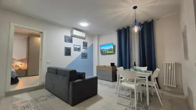 a living room with a couch and a table and chairs at Light Blue Station Apartment in Rome