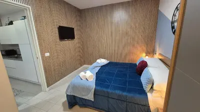 a bedroom with a blue bed and a television at Light Blue Station Apartment in Rome